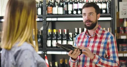 Wine Store Clerk Talks With Customer About Selection