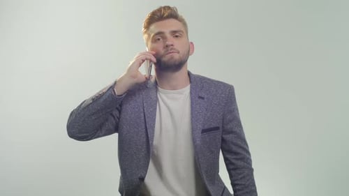 Young Adult Man Talking on Mobile Phone in Studio