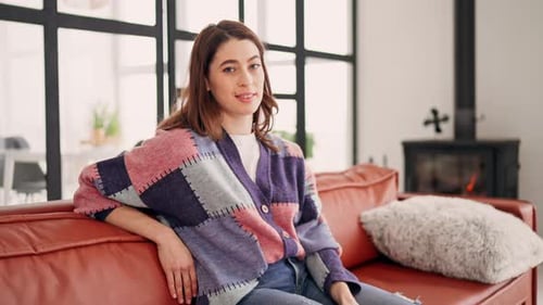 Smiling Woman Relaxing on Couch Indoors