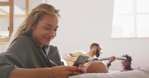 Friends Relaxing at Home with Guitar and Phone