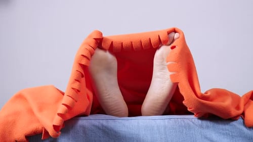 Pieds humains sous couverture