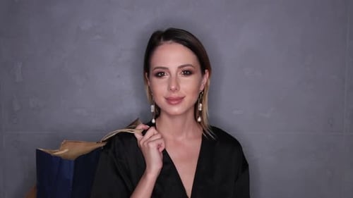 Glamorous Woman Smiling with Shopping Bags Thumbs Up