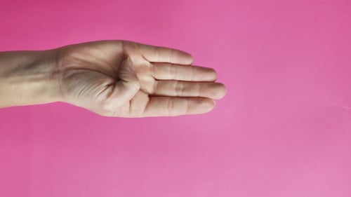 Hand Clenching into a Fist on Pink Background