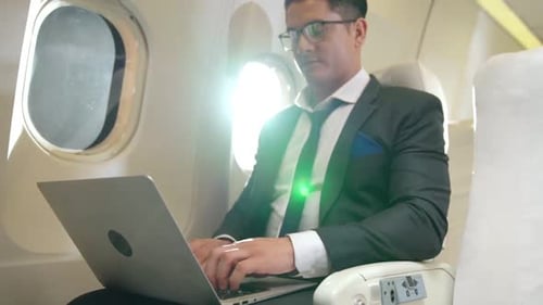 Young Adult Using Laptop on Airplane
