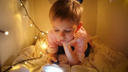 Young Boy Reading in a Cozy Lit Cubby