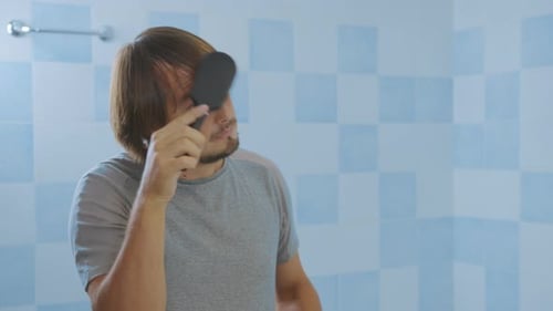 Man Brushing Hair Realizes He's Losing Hair