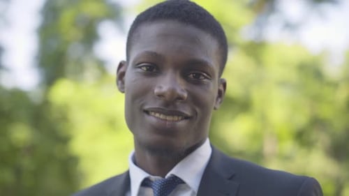 Portrait rapproché d'un jeune homme afro-américain regardant la caméra et souriant. Homme d'affaires positif