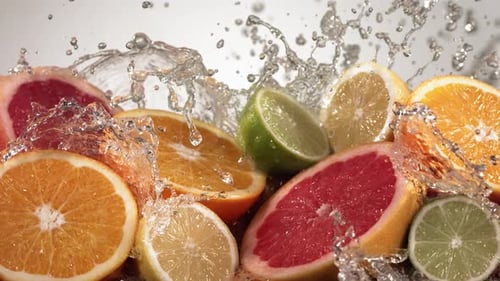 Slow Motion Shot of Citrus Fruits and Water Splashing Through Lemon Lime Grapefruit Slices