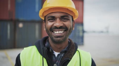 Happy Indian man working in logistic terminal of container cargo