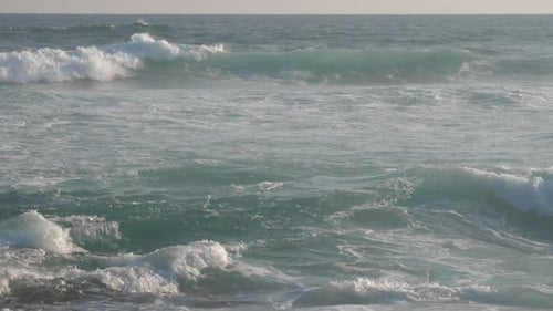 Huge Ocean Waves Roll on Beach Against Blue Sky Slow Motion