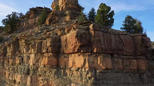 Viewing layers of dirt and rocks below the ground flying over cliff