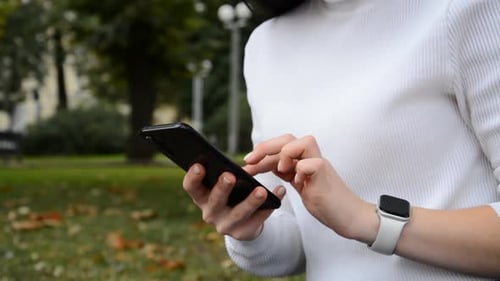 Woman Using Smartphone in City Park