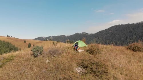Tourist Near Green Camping Tent in the Mountain Forest