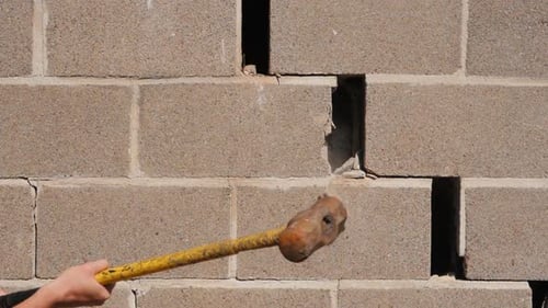 A Large Hammer Strikes the Brick Wall. Breaking Stereotypes