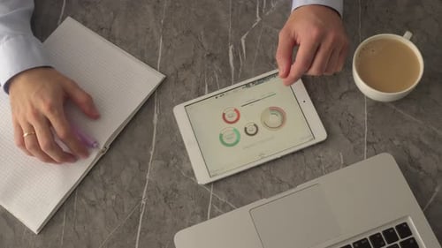 Man Touching Tablet with Charts at Modern Office