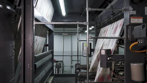 Printed newspapers moving on conveyor at high speed in printing factory