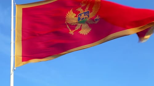 Red Flag Waving Against Clear Blue Sky