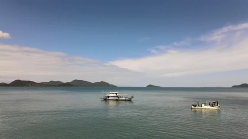 Orbiting aerial view of fishing boats on calm water, low angle