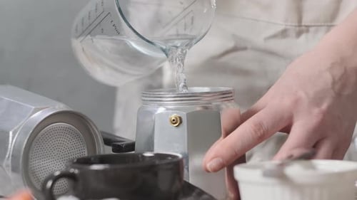 Person Making Espresso with Moka Pot at Home