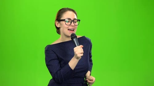 Woman Sings Energetically with Microphone on Green Screen