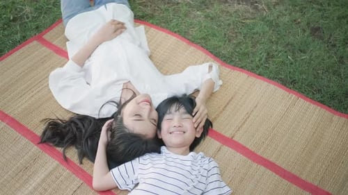Mother and son play together by lie on mat in home garden and they look happy
