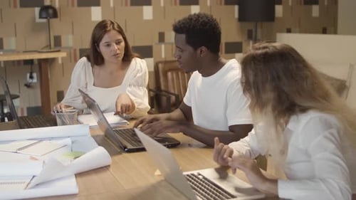 Diverse Team Collaborating on Laptops in Modern Office