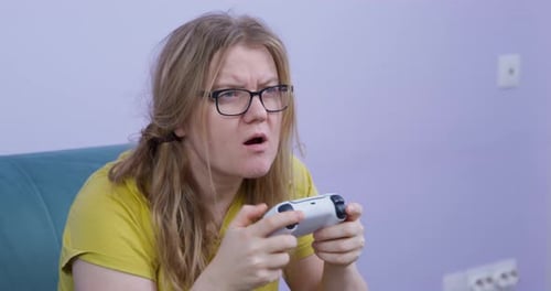 Woman Plays Video Game with Controller at Home