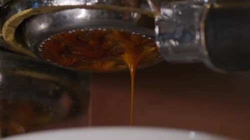 Pouring Coffee Stream From Professional Machine in Cup. Flowing Fresh Ground Coffee. Drinking