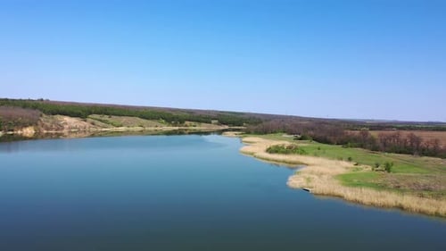 Lake among forest and agricultural fields. Aerial view.