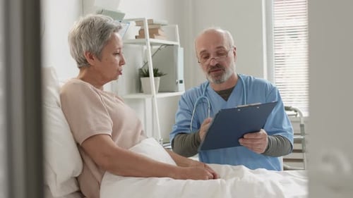 Doctor Consults with Senior Patient in Hospital Room