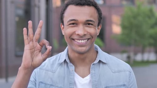 Man Smiles and Makes Okay Sign