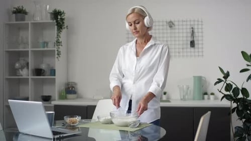 Woman with Headphones Cooking in Modern Kitchen