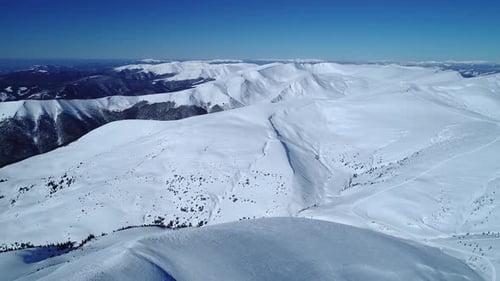 Flug über die türkisfarbenen Schneeberge, die von der Tagessonne beleuchtet werden