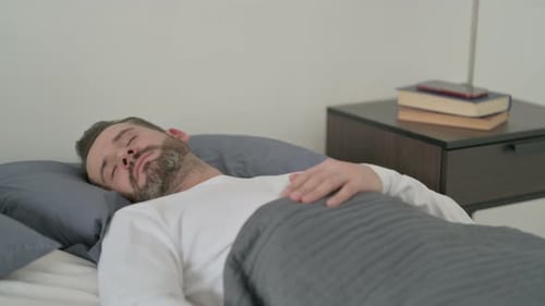 Homme se réveillant d'un cauchemar au lit