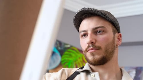 Young Bearded Artist Painting in Studio