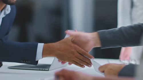 Handshaking above office desk