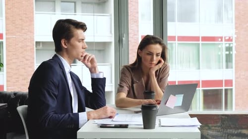 Heureux homme d'affaires et femme d'affaires caucasien travaillant tard dans un bureau moderne