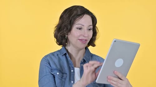 Woman Using Tablet on Yellow Background