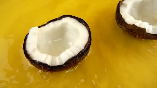 Two Coconut Halves in Yellow Liquid
