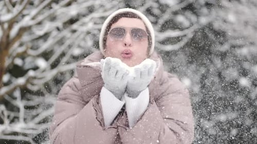 Woman Blowing Snow in Snowy Winter Scene