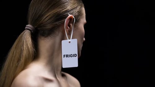 Mulher tirando etiqueta frígida da orelha, protesto contra inseguranças no sexo