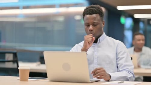 Young Adult Typing on Laptop in Office