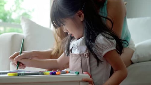 Child Drawing With Parent at Sunny Home Table