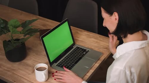 Caucasian Businesswoman Has Video Call Chatting on Laptop with Green Screen Chromakey in Office