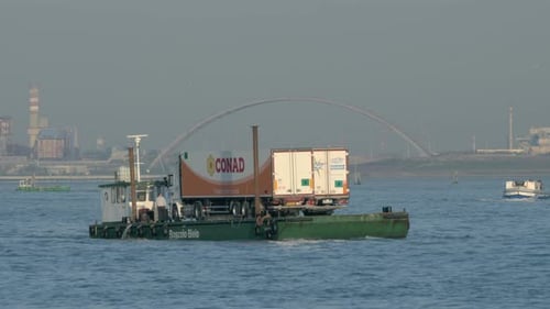 Barge Carrying a Trailer Truck Sailing on Water