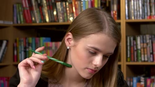 Portrait of Student in a Library. Beautiful Female Student, Writes the Abstract