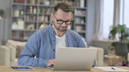 Focused Young Man Working on Laptop