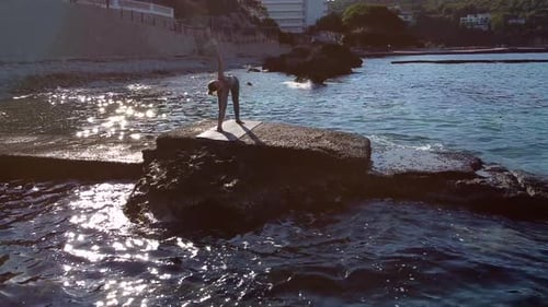Femme faisant du yoga au bord de mer