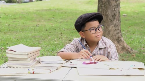 Young Boy Drawing With Watercolors Outdoors