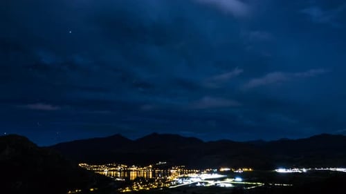 Time-Lapse of a City at Night with Starry Sky